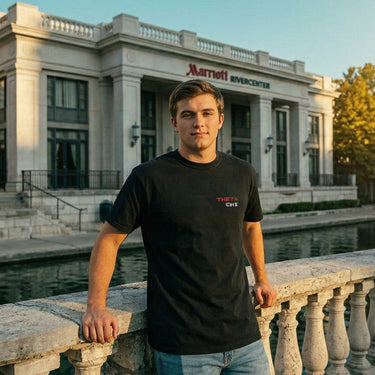 Front view of a model wearing the black Theta Chi F1 tee with a minimal Theta Chi chest graphic.