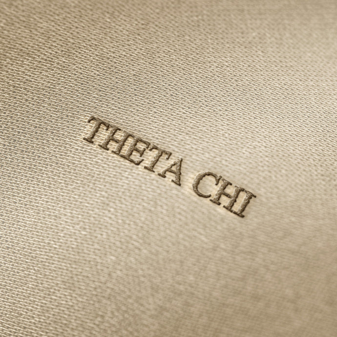 Soft beige fabric close-up showing a smooth, heavyweight knit texture with gentle folds and subtle draping.