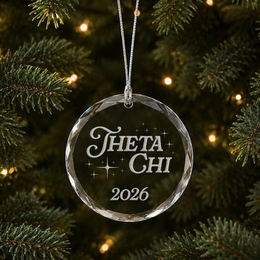 Limited Edition glass Christmas ornament with engraved design hanging on a decorated holiday tree